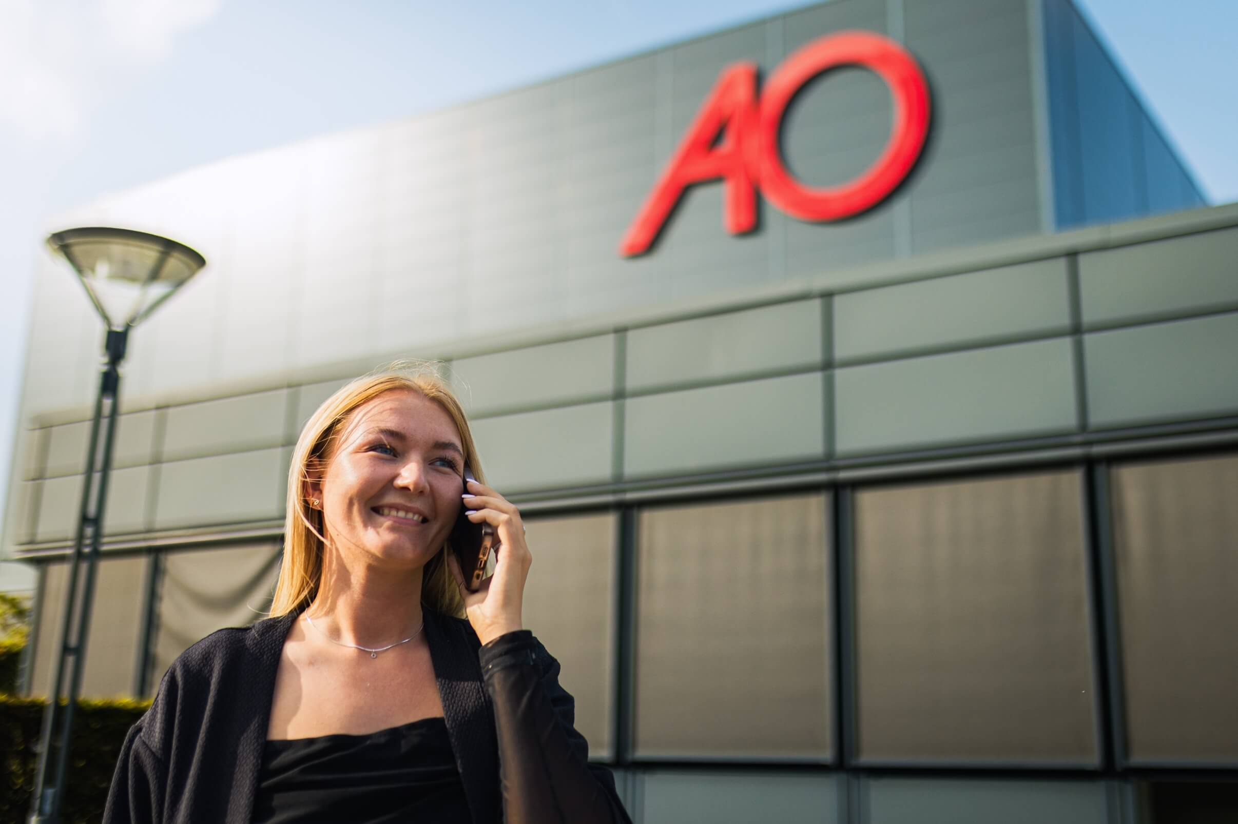 Celina snakker i telefon foran AO's hovedkontor